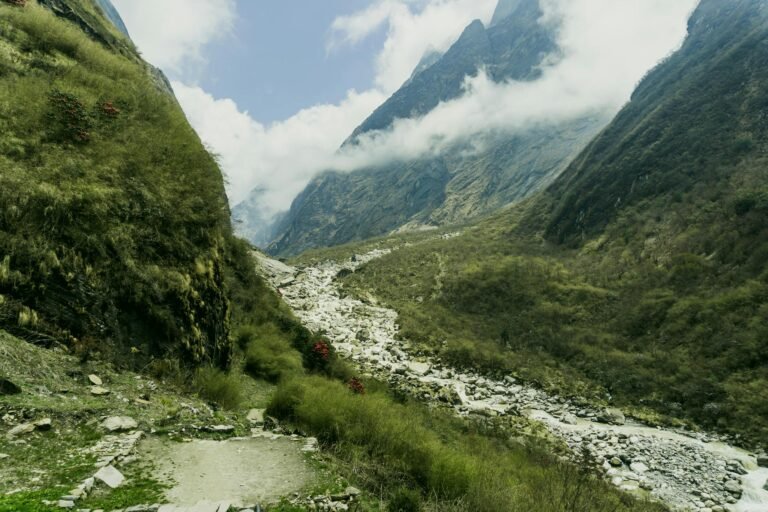 Breathtaking view of Annapurna's lush valley with rugged mountains and cloudy skies.