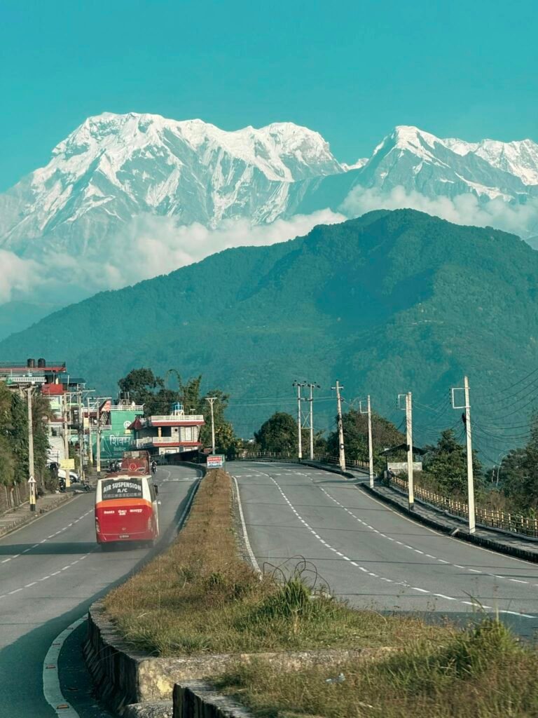 Bustling road in Nepal with a stunning view of the Himalayas, capturing the essence of travel.